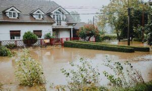Flooded residential property - ALTA SURVEY Miami Flooded suburban home surrounded by standing water after heavy rain, showing how floods can affect property boundaries