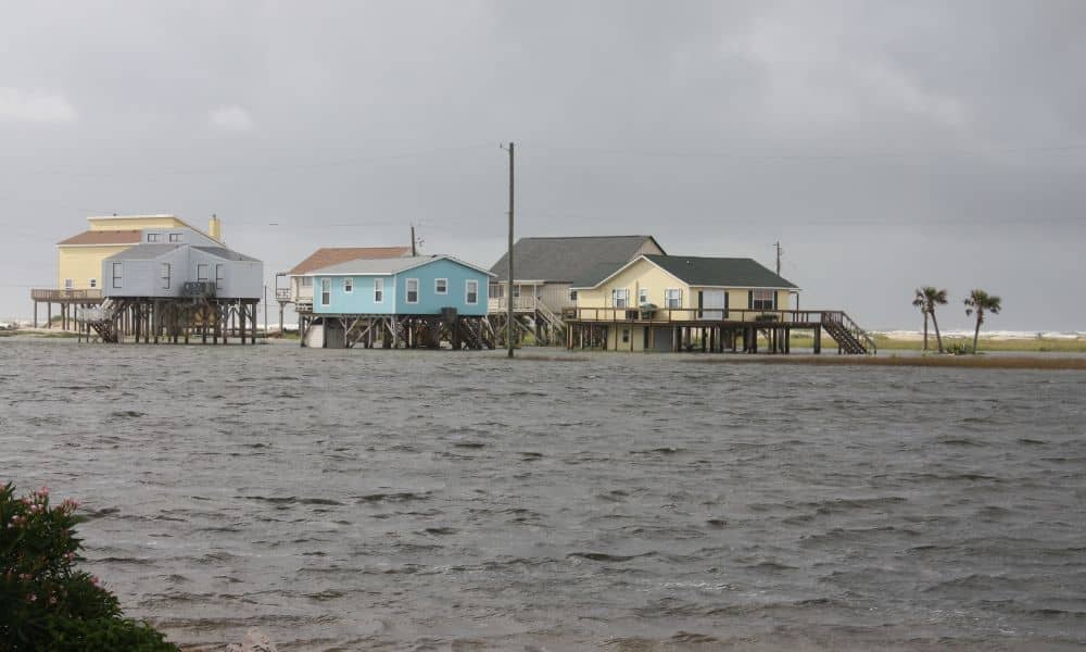 Elevated coastal homes surrounded by high water during a sunny-day flood showing the importance of an accurate elevation certificate


