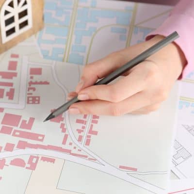 Hand reviewing a property map to confirm boundaries and identify issues during a due diligence survey