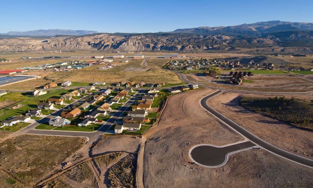 A cadastral surveyor reviewing property boundaries near expanding urban development areas
