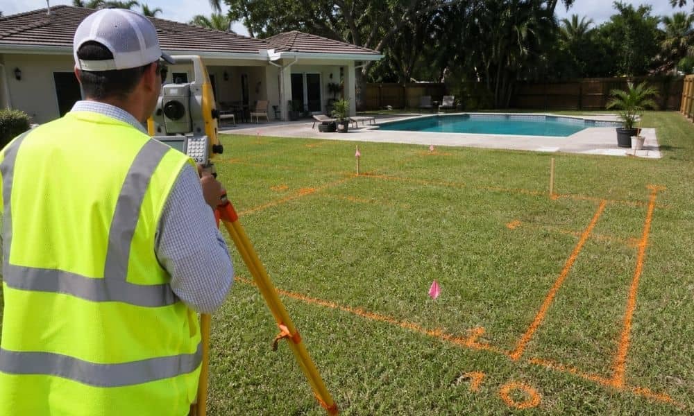 Residential surveyor marking a backyard before a pool is built